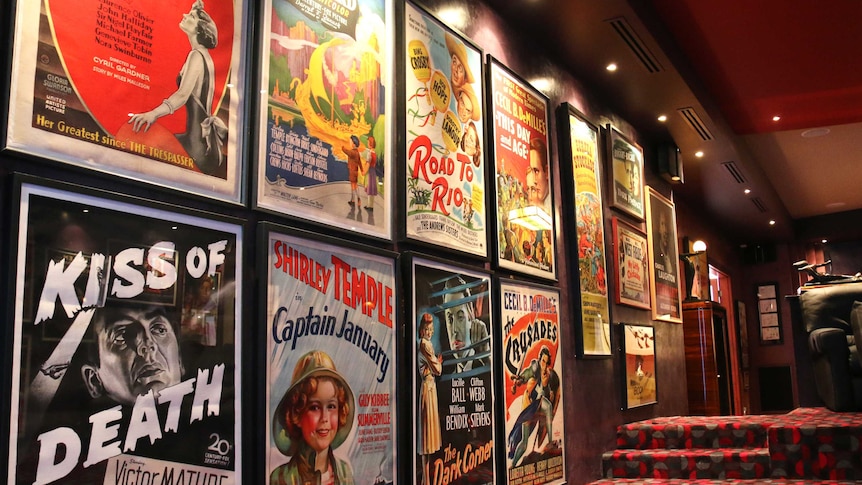 Movie posters hanging on a wall in a home cinema.