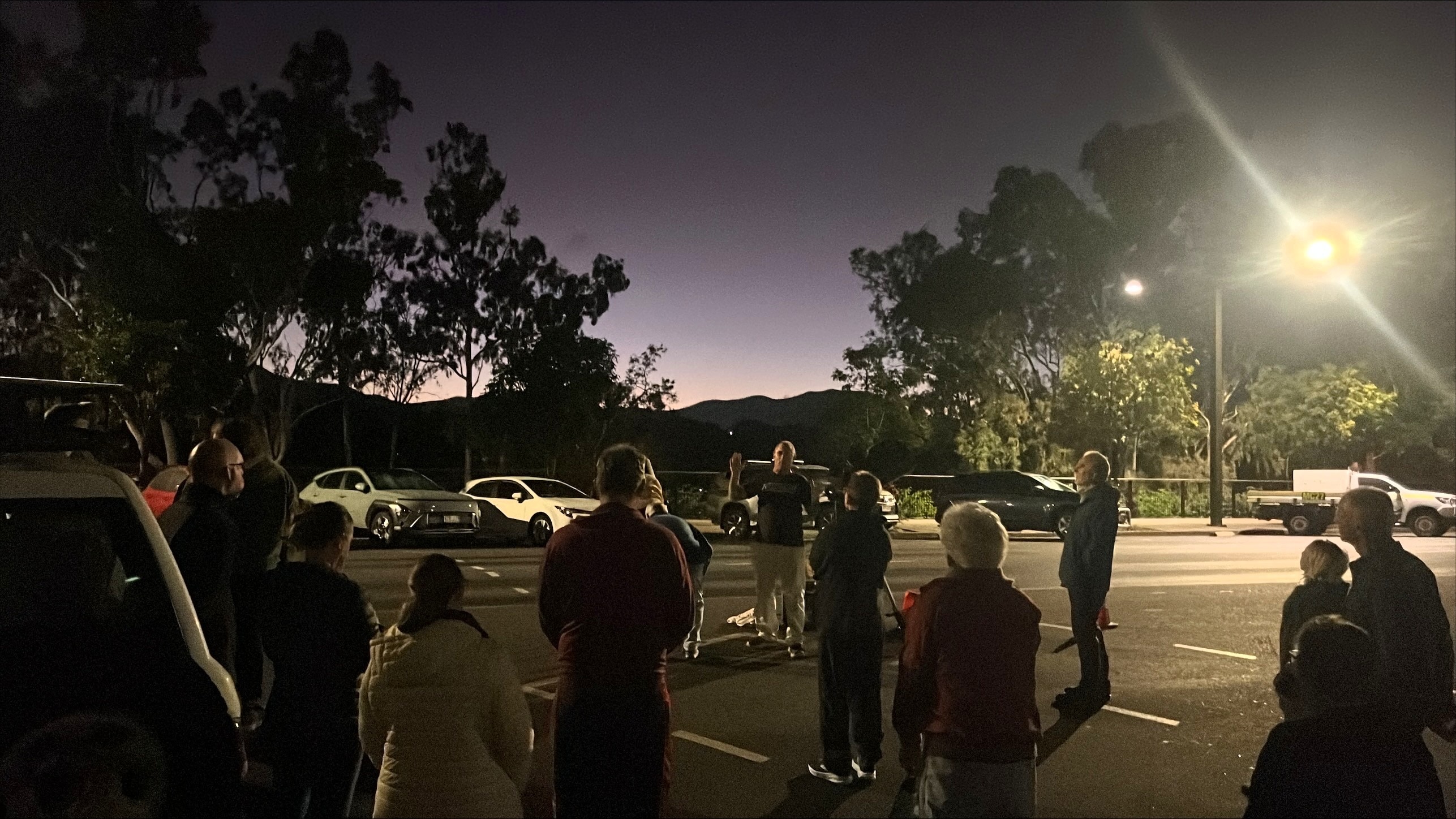 Photo of people at sunrise looking at the sky