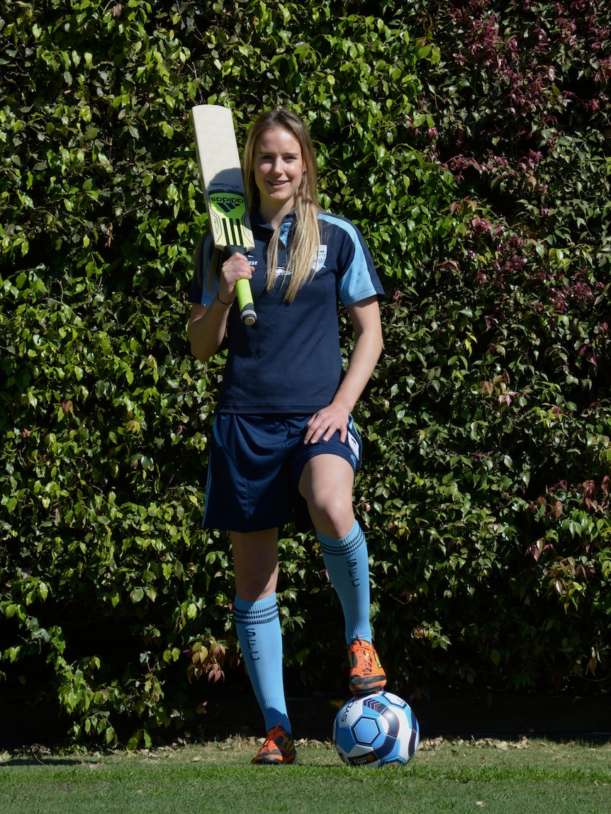 Ellyse Perry poses with a cricket bat and a football