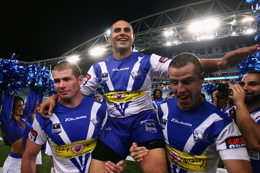 Hazem El Masri is carried off the field by Andrew Ryan and Luke Patten.