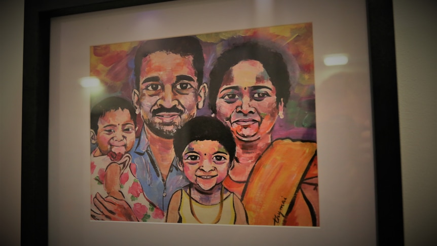 A painting with bright orange, pink, white colours of the Sri Lankan family, the mum, dad and two young girls, all smiling. 