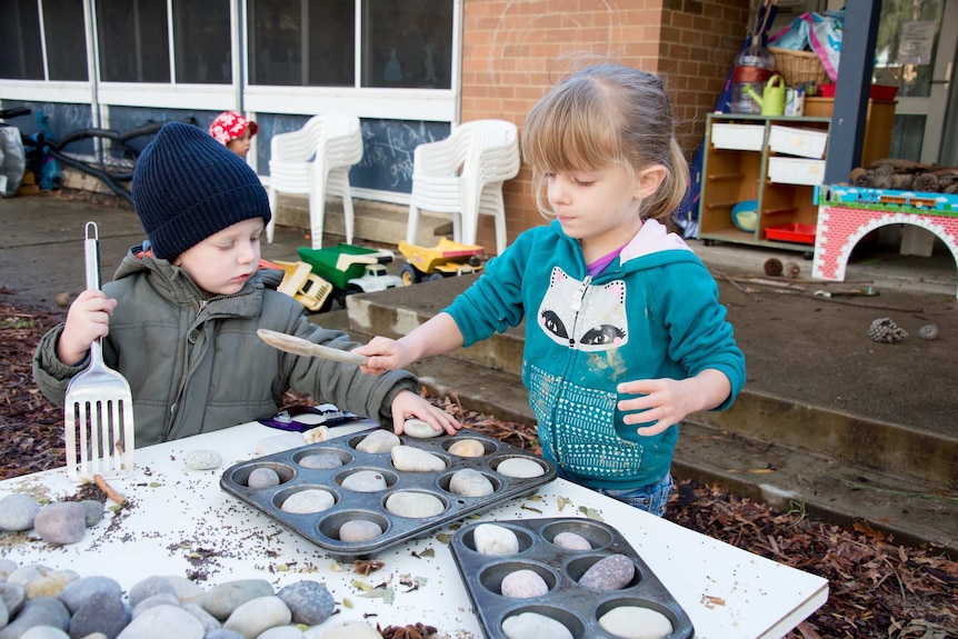Two children 'cooking rocks'