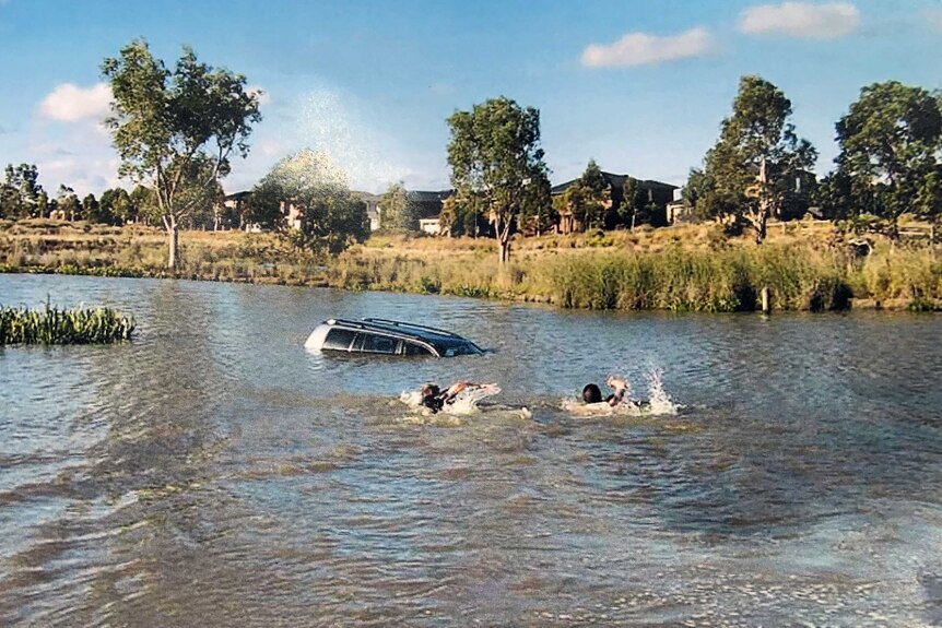 Rescuers attempt to save the children of Akon Guode swimming to the four-wheel-drive in a lake.