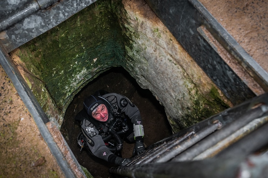 A diver lowers himself into Tank Cave near Mount Gambier.