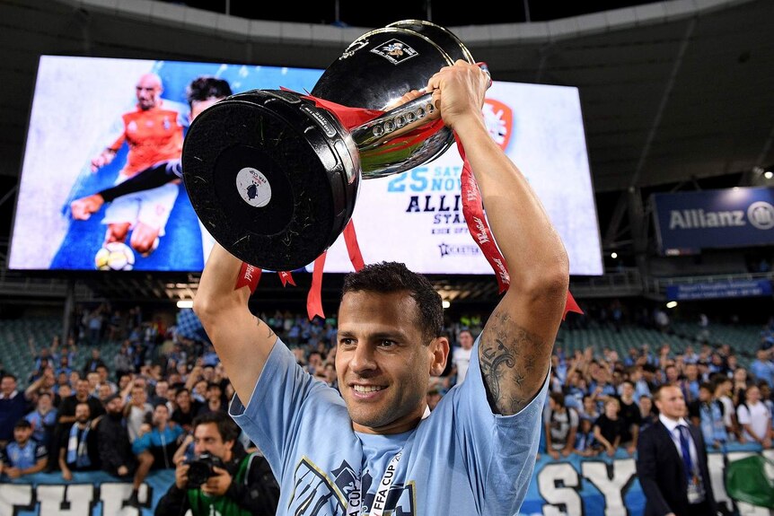 Bobo of Sydney holds up the FFA Cup trophy