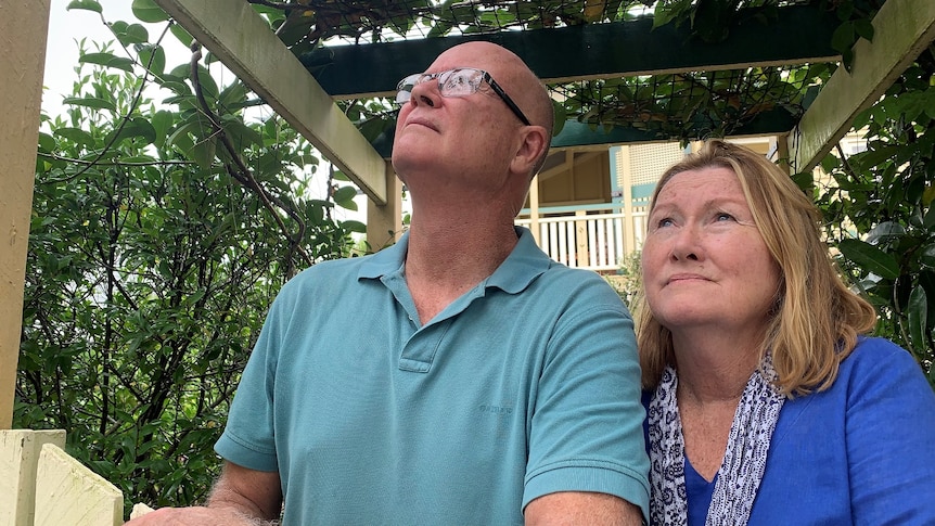 Annerley residents Tony and Andrea Sticklen lean against the front fence of their house in Brisbane.