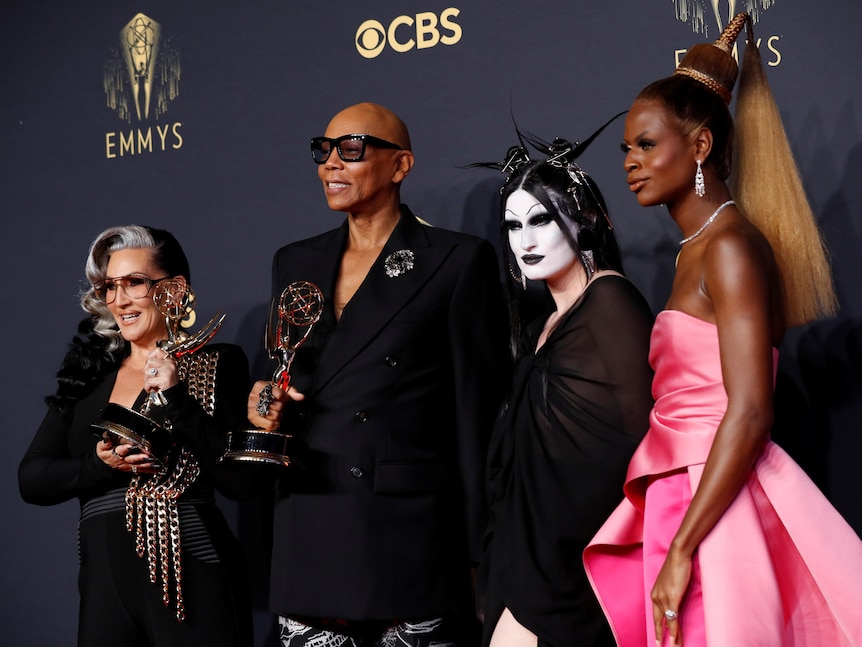 Michelle Visage and RuPaul hold up Emmy awards with Gottmik and Symone next to them in drag