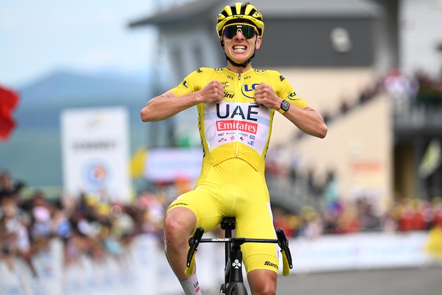 Tadej Pogačar beats his chest as he celebrates winning stage 14 of the Tour de France.