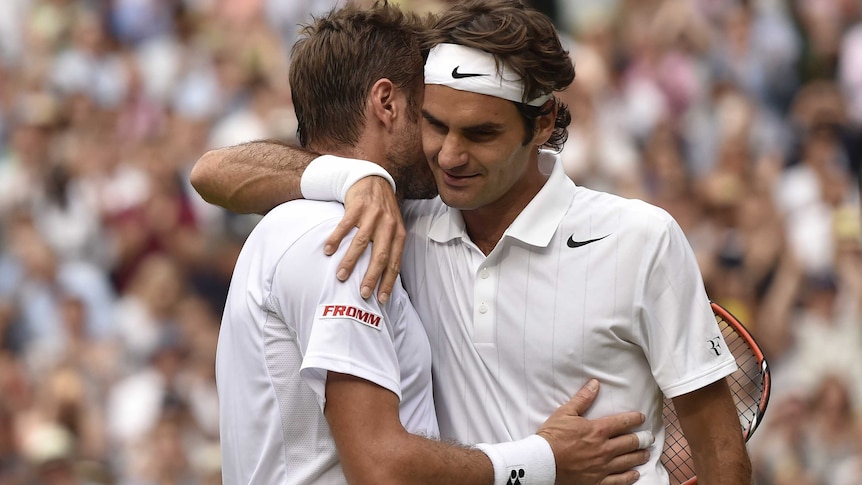Roger Federer hugs compatriot Stan Wawrinka at Wimbledon