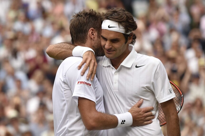 Roger Federer hugs compatriot Stan Wawrinka at Wimbledon
