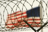 American flag waves within the razor wire-lined compound of Camp Delta