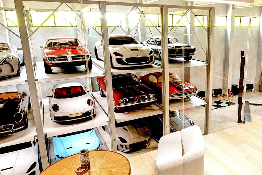 Three rows of luxury cars stacked up in a garage 