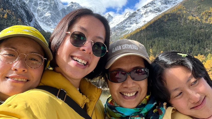 Maggie Zhou takes a selfie with her mum and two sisters in front of snow capped mountains at Jiuzhaigou national park. 