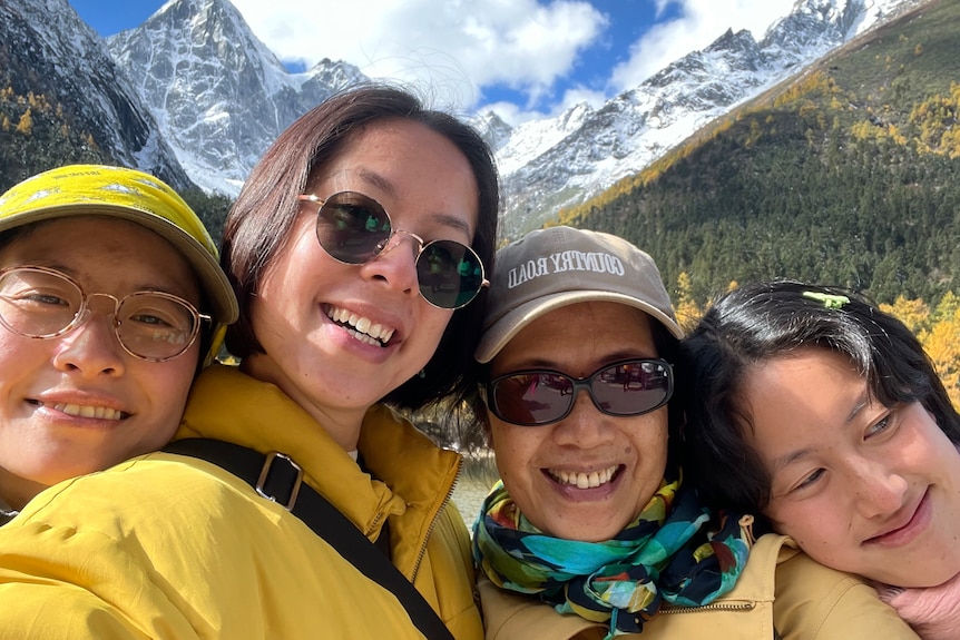 Maggie Zhou takes a selfie with her mum and two sisters in front of snow capped mountains at Jiuzhaigou national park. 