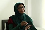 An Indonesian woman gestures with her hands as she speaks.
