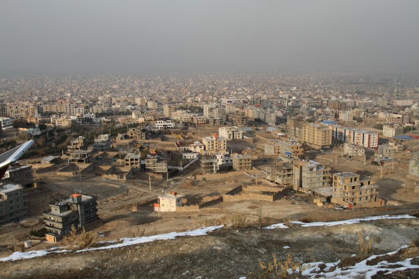 A view of Omid-e-Sabz Town Kabul from a hill with small traces of snow on sand