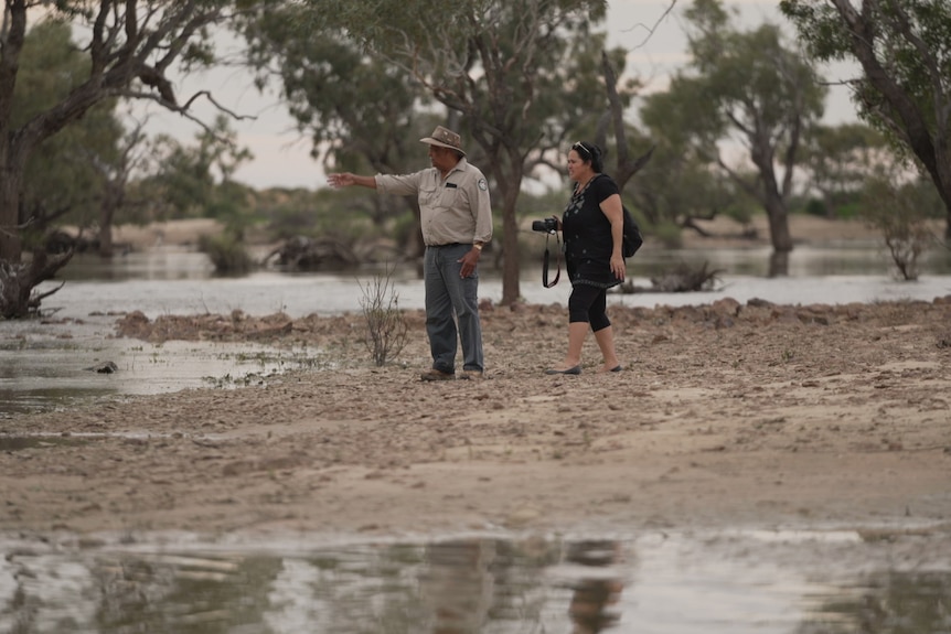 A ranger and a photographer documenting flooding in Eyre Creek
