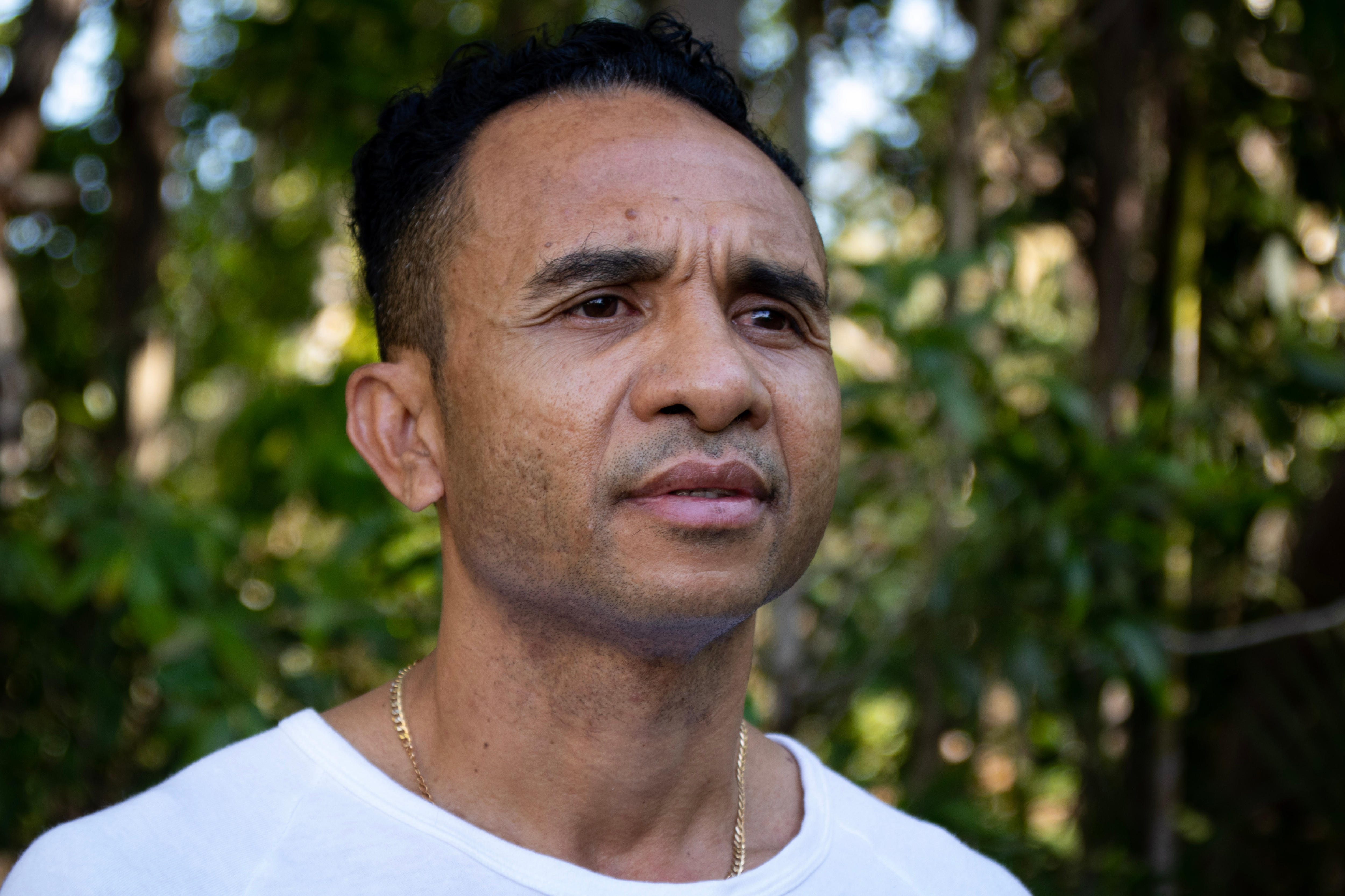 A portrait of a man outside looking into the distance.