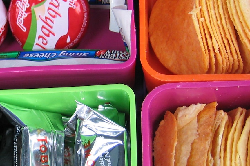 A lunch box filled with snack foods.
