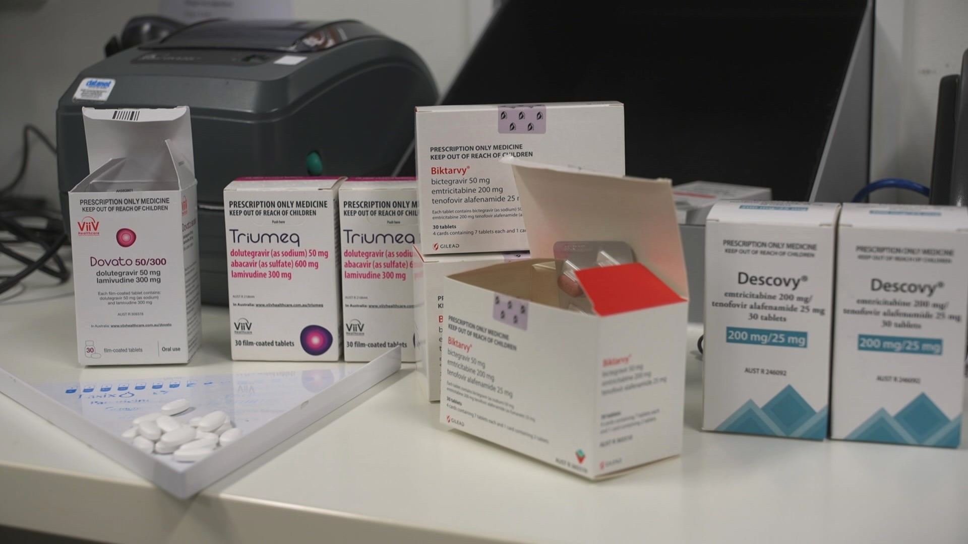 Boxes and bottles of white pills on a white tabletop