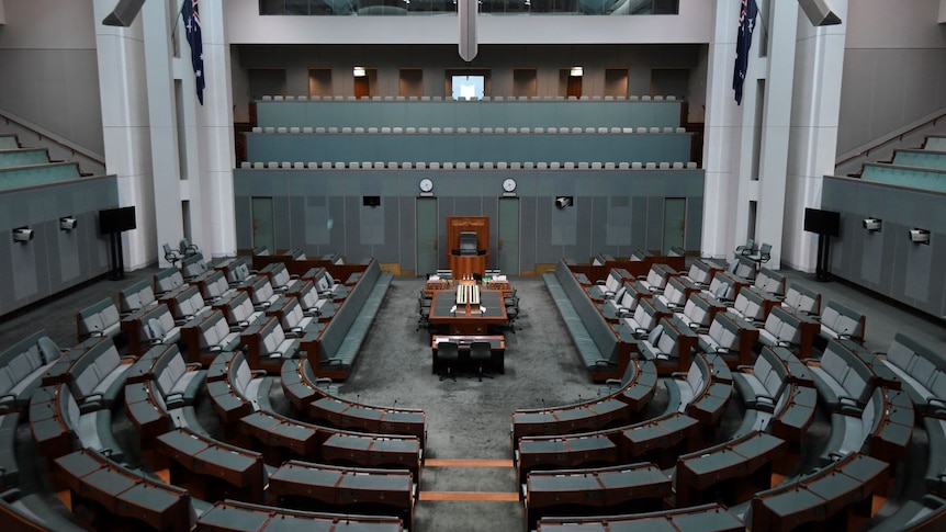 A completely empty chamber of the House of Representatives with not a single person in the green seats.