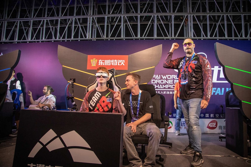 Rudi Browning from Australia competes at the World Drone Racing Championships. He is wearing goggles and sitting down.