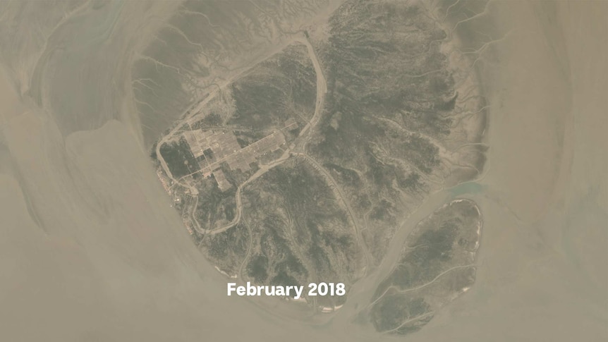 A satellite image showing roads and red roofs of houses appearing on a small island