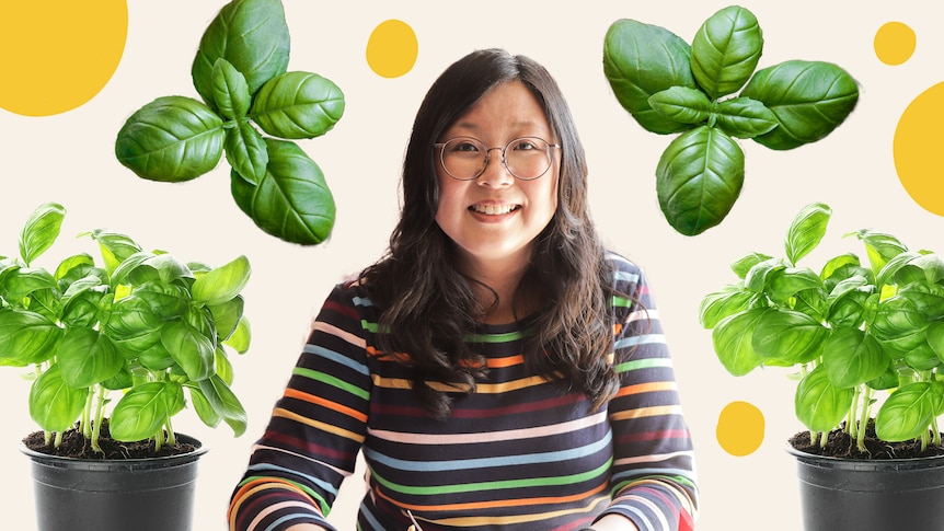 Jennifer Wong with a pot of basil on either side of her.