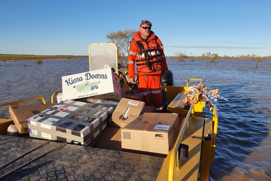 A volunteer with supplies in floodwaters.