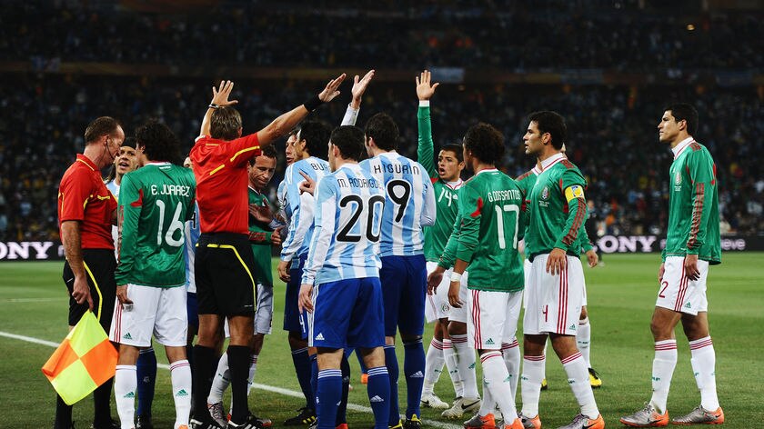 Mexico players surrounded the referee after big screens showed replays of Tevez's offside goal.