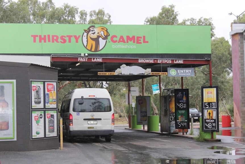 A taxi parked at the drive-through of the Thirsty Camel.