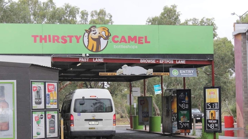 A taxi parked at the drive-through of the Thirsty Camel.