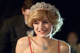 Actor Emma Corrin as Princess Diana, red spotty dress and blonde hair adorned with a small crown