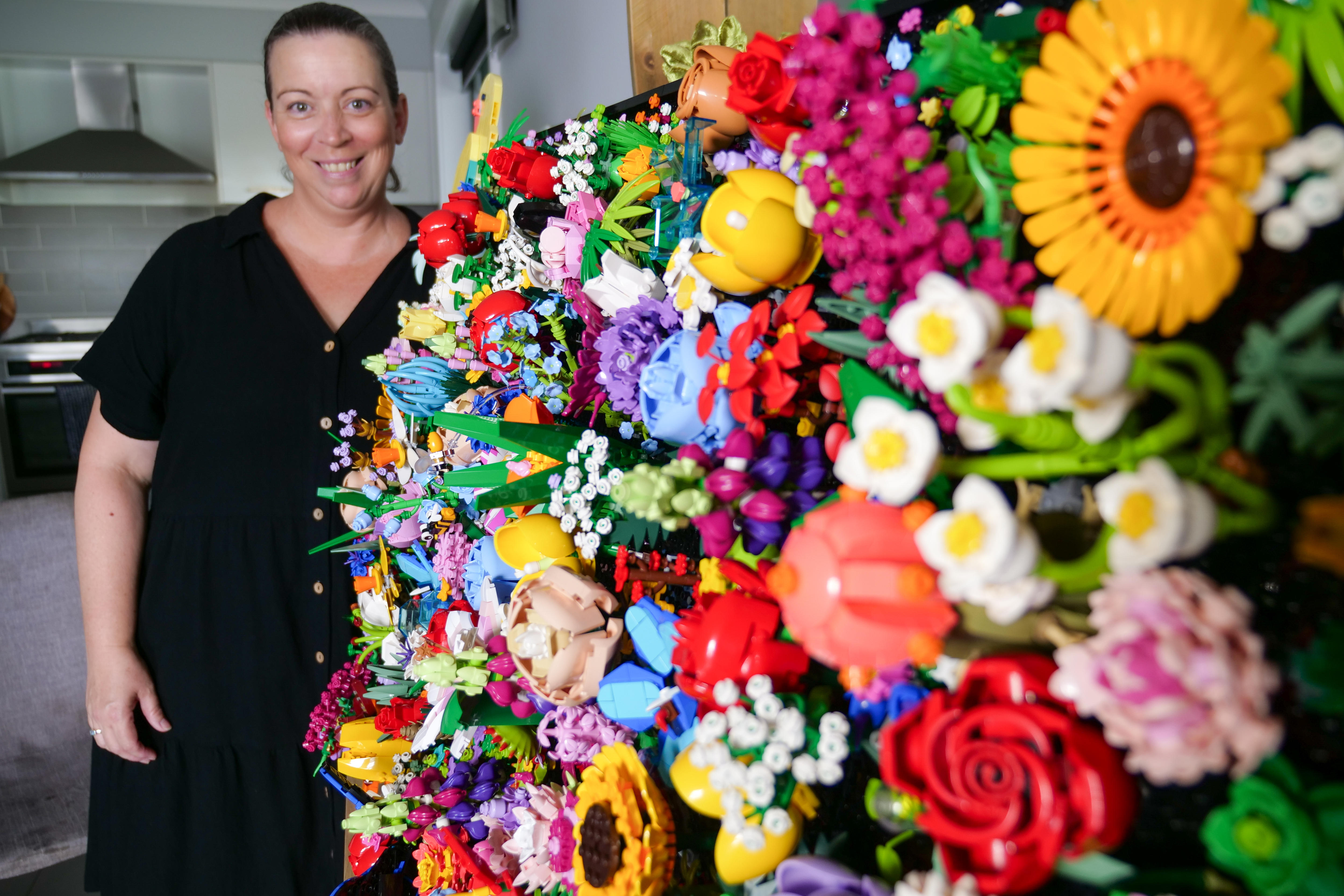 Wendy stands behind her Lego artwork 