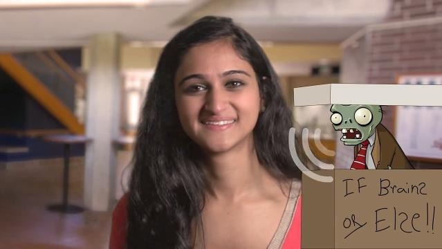 Woman sits in room, computer image of skeleton zombie climbing out of box beside her