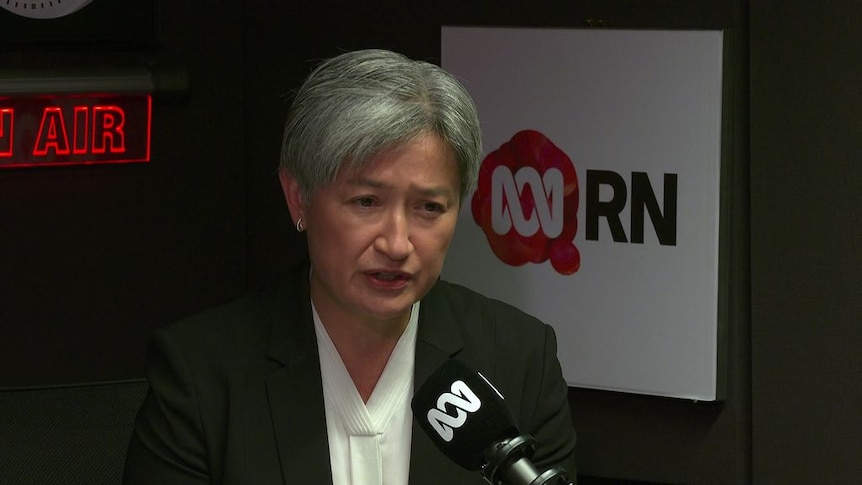 Penny Wong gives a radio interview, with the ABC Radio National logo behind her.