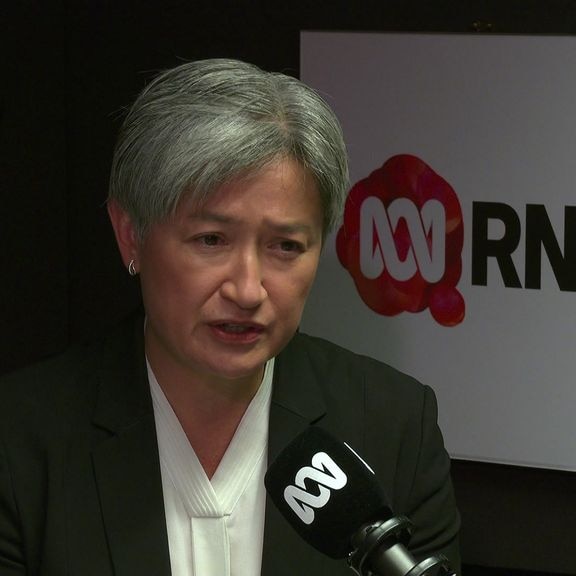 Penny Wong gives a radio interview, with the ABC Radio National logo behind her.