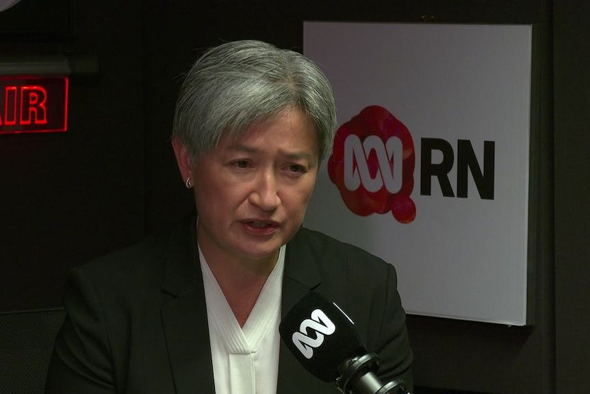 Penny Wong gives a radio interview, with the ABC Radio National logo behind her.