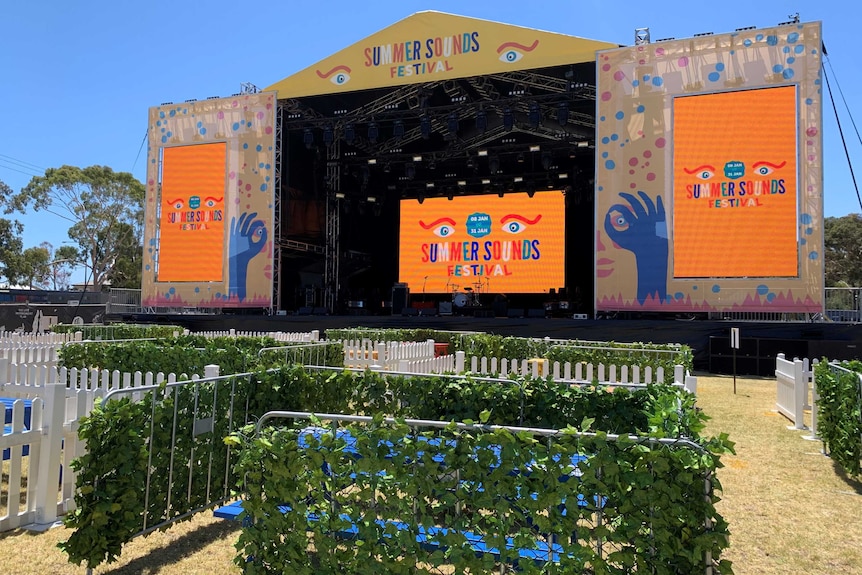 A concert stage with pens in front covered in leaves