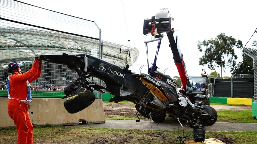 Wreck of Fernando Alonso's car is retrieved from circuit at 2016 Australian F1 Grand Prix.