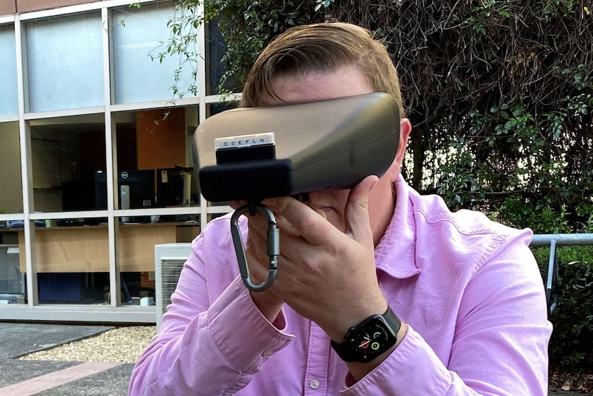 A man looks into a mobile vision testing device.