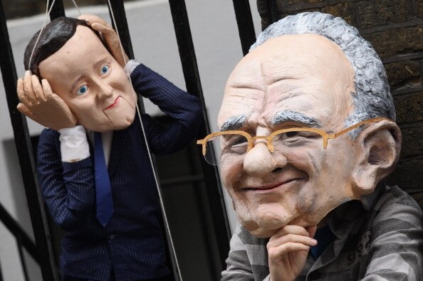 A protester wearing a Rupert Murdoch mask demonstrates with a David Cameron puppet. (Getty Images: Oli Scarff)