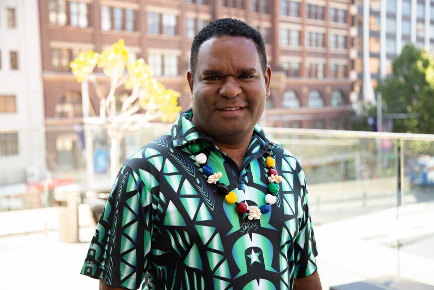 Man in Torres Strait shirt in a city.