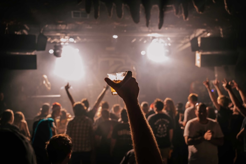 Crowd raising arms to musicians on stage in Badlands, Perth