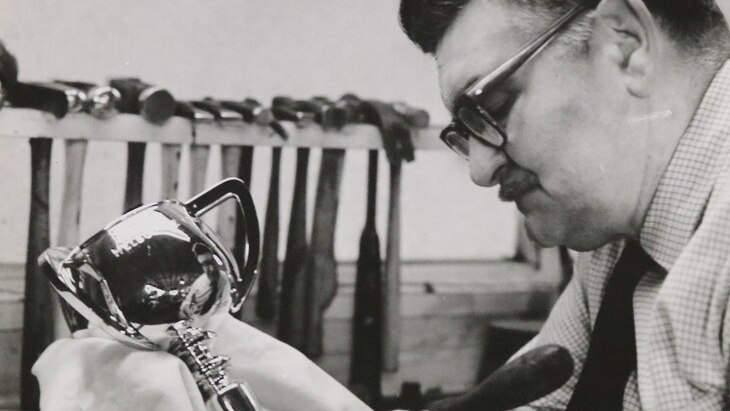 Black and white photo of man working on Cup trophy