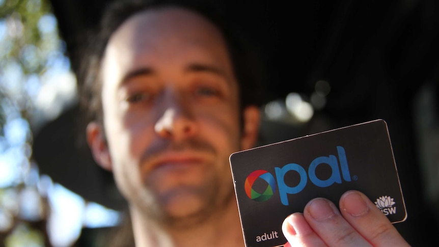 A man holding up an opal card.