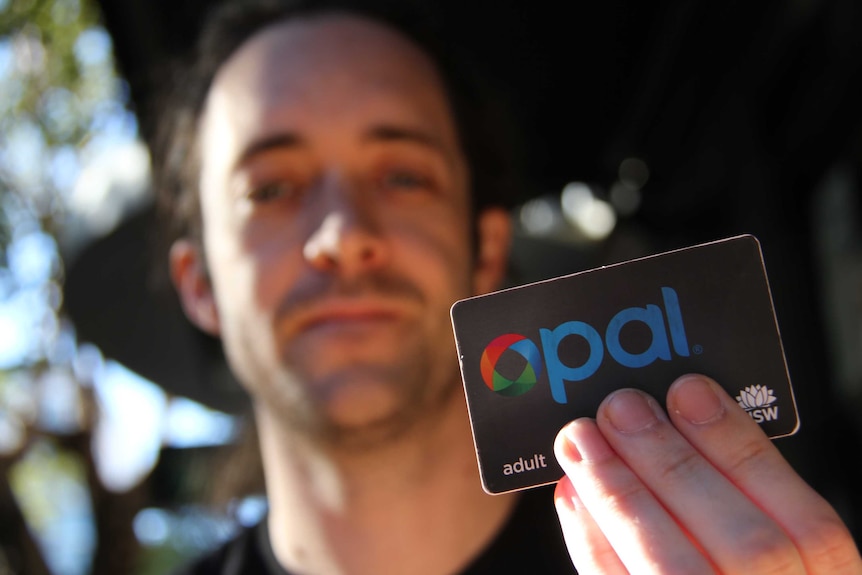 A man holding up an opal card.