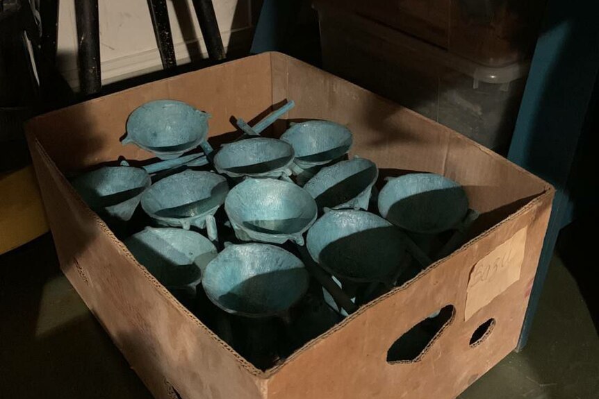 blue copper funnels sitting in a cardboard box.