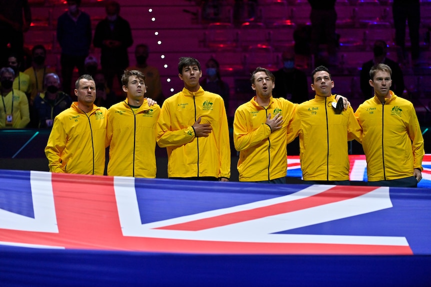 Six Australian tennis player standing with their arms around one another while singing the Australian anthem at the Davis Cup