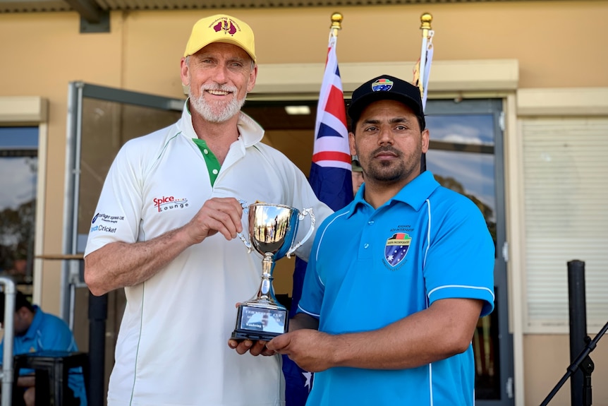 Two men holding a trophy